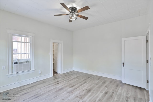 spare room featuring cooling unit, light wood-type flooring, and ceiling fan