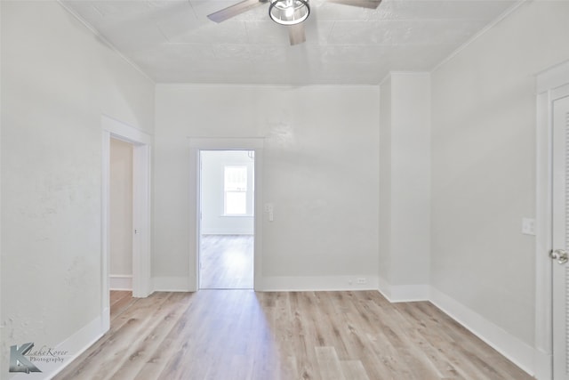 empty room featuring crown molding, light hardwood / wood-style flooring, and ceiling fan