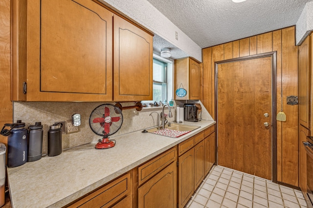 kitchen with light tile patterned flooring, sink, and a textured ceiling