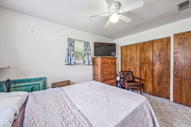 bedroom featuring carpet, ceiling fan, and a textured ceiling