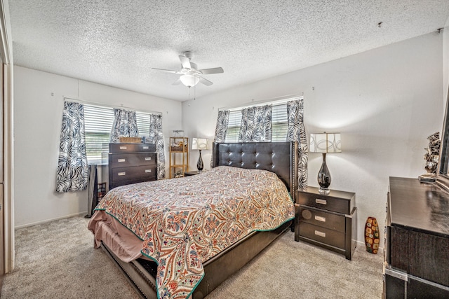 bedroom with light carpet, ceiling fan, and a textured ceiling