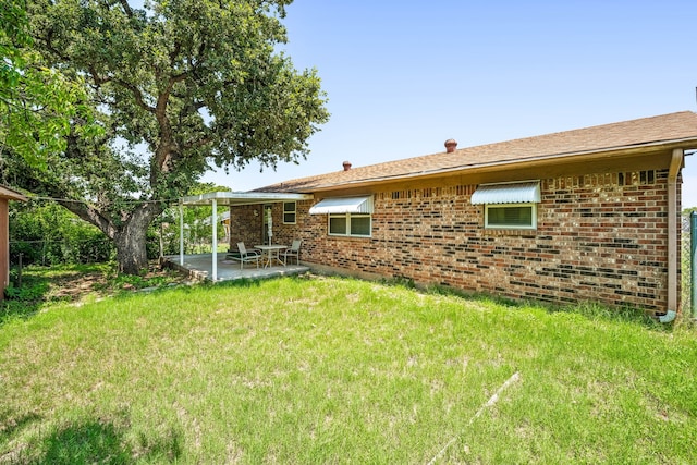 rear view of house with a patio area and a yard