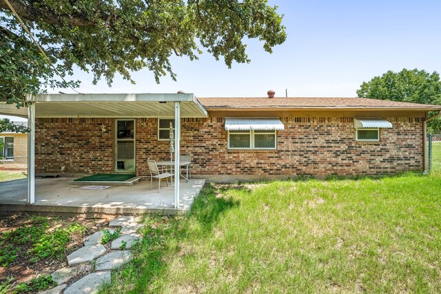 back of property featuring a patio and a yard