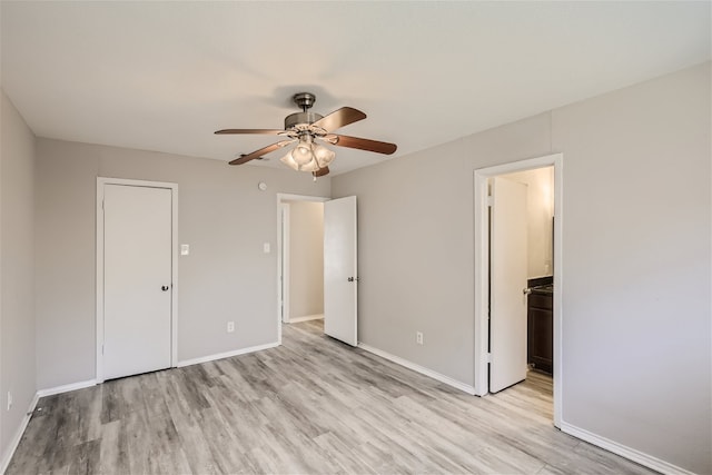 unfurnished bedroom featuring ceiling fan, ensuite bathroom, and light hardwood / wood-style floors