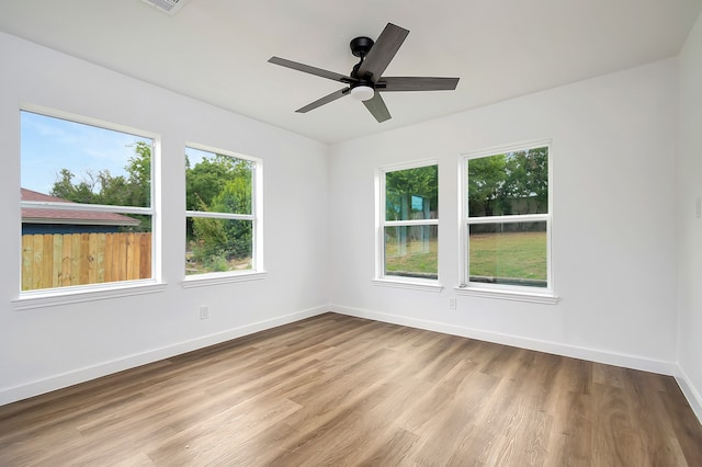 spare room with ceiling fan, light hardwood / wood-style floors, and plenty of natural light