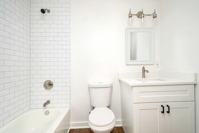 full bathroom with tiled shower / bath combo, vanity, wood-type flooring, and toilet