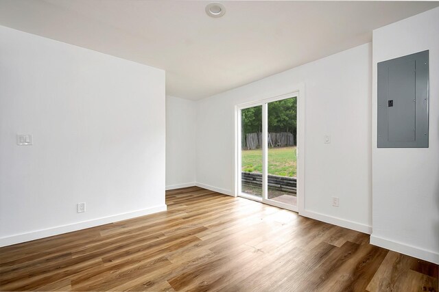 unfurnished room featuring hardwood / wood-style floors and electric panel