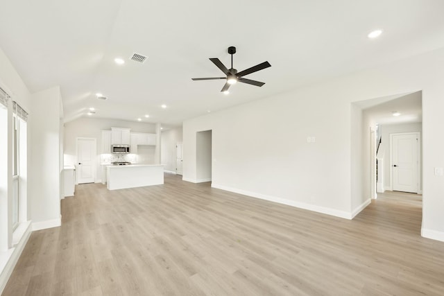 unfurnished living room featuring ceiling fan, vaulted ceiling, and light hardwood / wood-style flooring