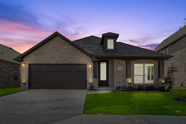 view of front of home with a garage and a yard