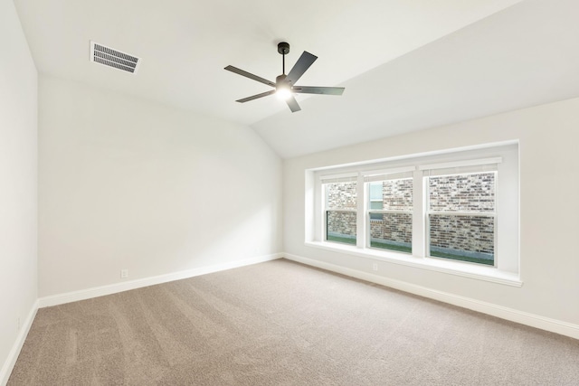 carpeted spare room featuring lofted ceiling and ceiling fan