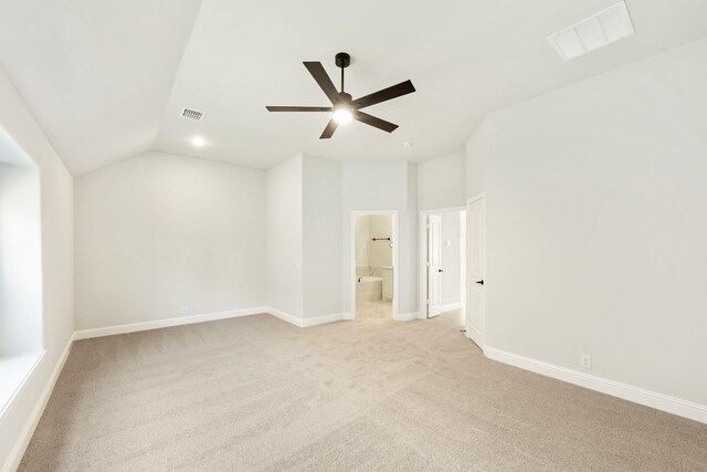 unfurnished room with ceiling fan, light carpet, and vaulted ceiling