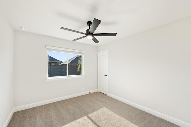 carpeted spare room featuring ceiling fan