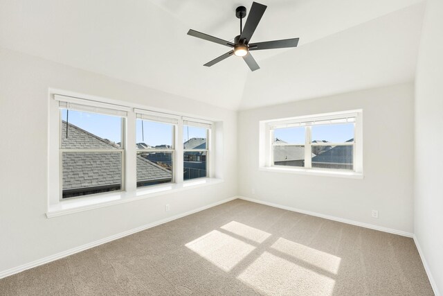 unfurnished room featuring carpet flooring, ceiling fan, lofted ceiling, and a wealth of natural light