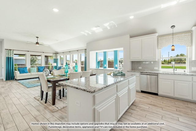 kitchen with tasteful backsplash, a center island, hanging light fixtures, dishwasher, and white cabinets