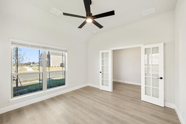 spare room featuring french doors, light wood-type flooring, vaulted ceiling, and ceiling fan