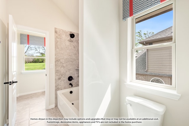 bathroom with lofted ceiling, tiled shower / bath combo, toilet, and tile patterned floors