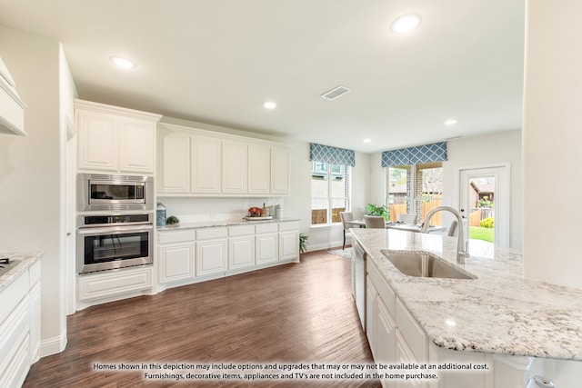 kitchen with white cabinets, dark hardwood / wood-style floors, appliances with stainless steel finishes, and sink