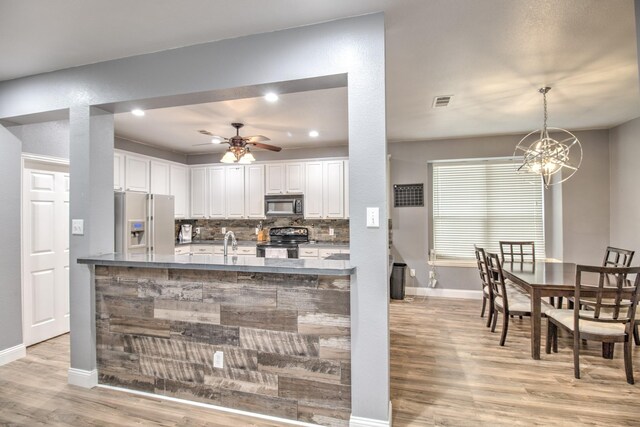 kitchen featuring light hardwood / wood-style flooring, black appliances, white cabinetry, and tasteful backsplash