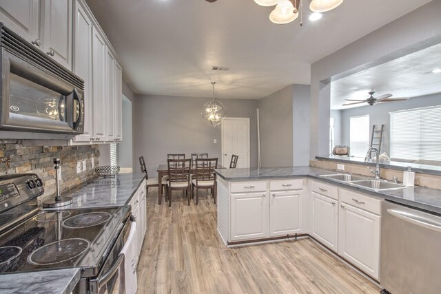 kitchen with light hardwood / wood-style flooring, kitchen peninsula, ceiling fan, appliances with stainless steel finishes, and sink