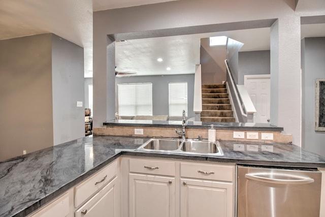 kitchen featuring kitchen peninsula, sink, stainless steel dishwasher, and white cabinets