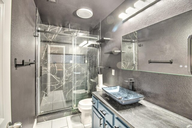 bathroom with vanity, tile patterned floors, walk in shower, and toilet