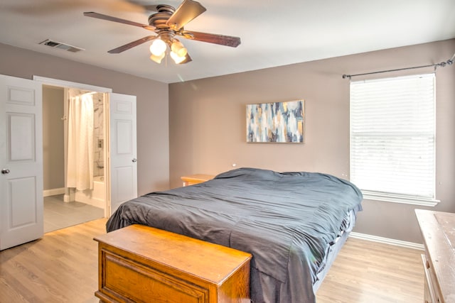 bedroom with ensuite bathroom, light wood-type flooring, and ceiling fan