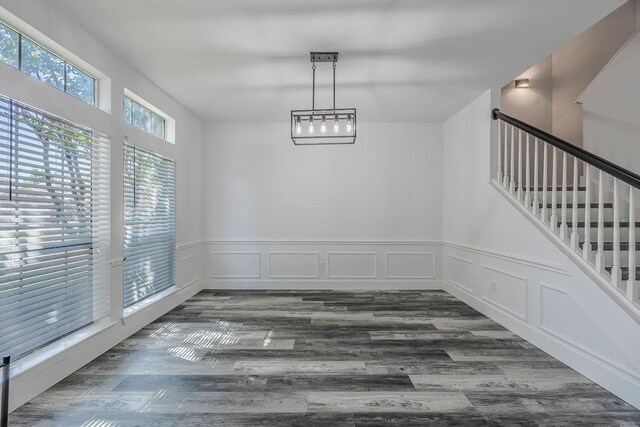 unfurnished dining area featuring hardwood / wood-style floors and an inviting chandelier