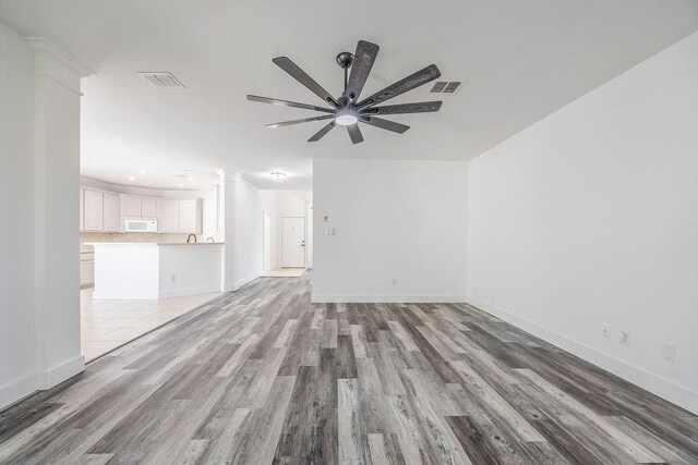 unfurnished living room with hardwood / wood-style floors and ceiling fan