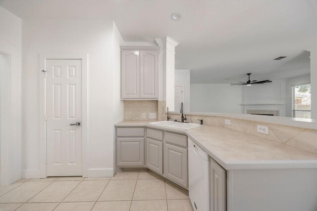 kitchen featuring light tile patterned floors, decorative backsplash, dishwasher, ceiling fan, and sink