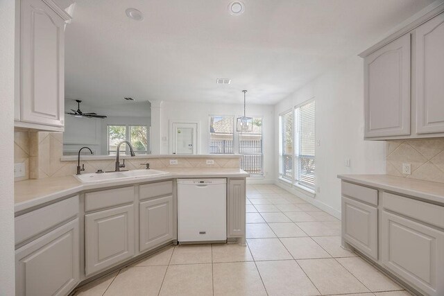 kitchen with pendant lighting, decorative backsplash, white dishwasher, ceiling fan, and kitchen peninsula