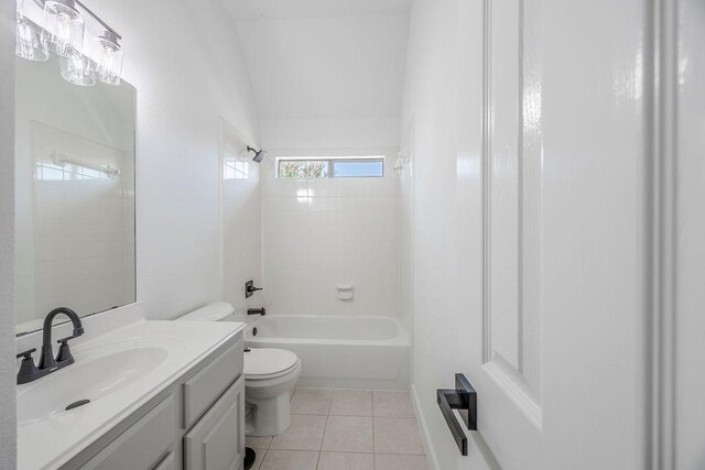 full bathroom with toilet, tiled shower / bath combo, vanity, and tile patterned floors