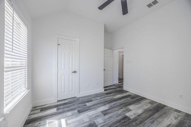 unfurnished bedroom featuring ceiling fan, wood-type flooring, vaulted ceiling, and multiple windows