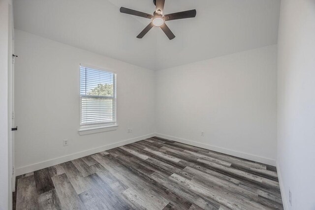 spare room with dark wood-type flooring and ceiling fan