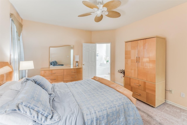 bedroom featuring connected bathroom, light colored carpet, ceiling fan, and a closet