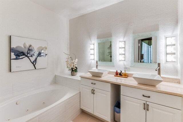 bathroom featuring independent shower and bath, vanity, and tile patterned floors