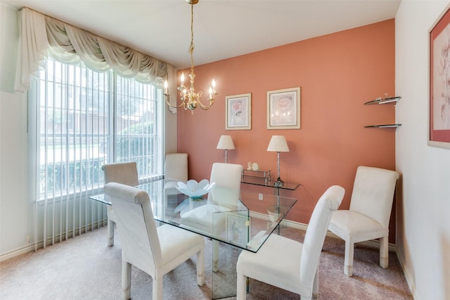 dining room featuring light carpet and a chandelier