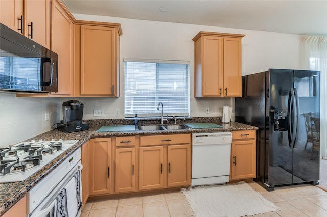 kitchen featuring sink, decorative backsplash, dark stone counters, light tile patterned floors, and black appliances