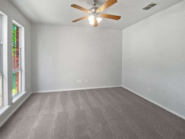 empty room featuring carpet floors, a healthy amount of sunlight, and ceiling fan