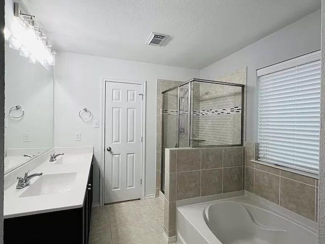 bathroom featuring vanity, shower with separate bathtub, tile patterned flooring, and a textured ceiling