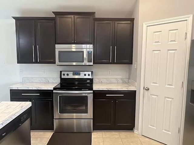 kitchen featuring light tile patterned flooring, appliances with stainless steel finishes, and dark brown cabinets