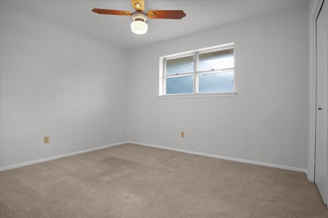 carpeted spare room with ceiling fan