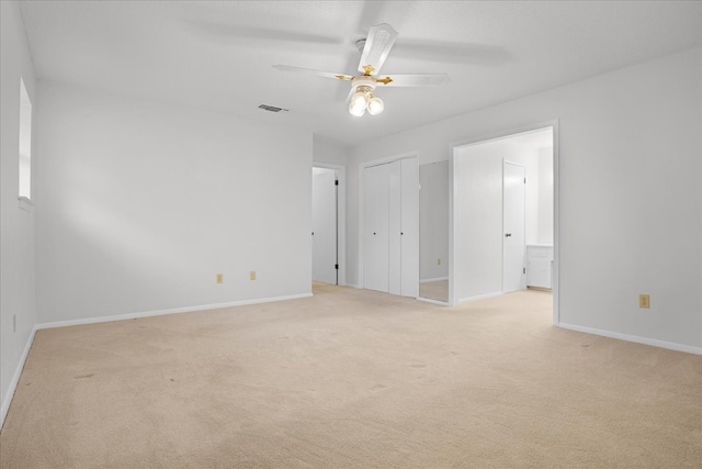 carpeted spare room featuring ceiling fan