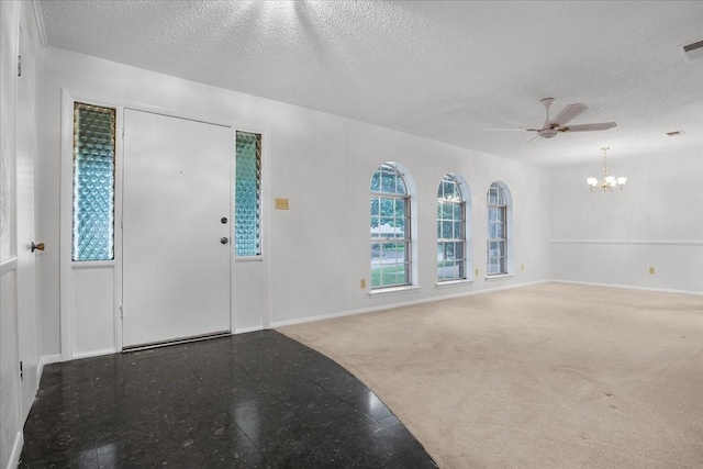 carpeted foyer entrance with ceiling fan with notable chandelier and a textured ceiling