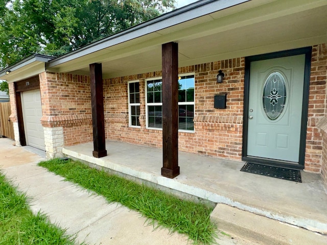 view of exterior entry with covered porch and a garage