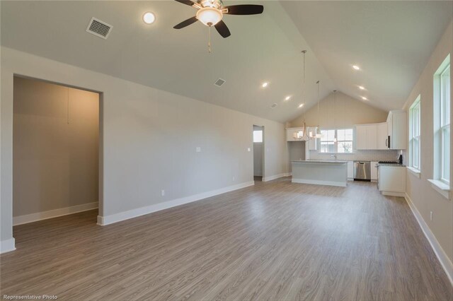 unfurnished living room featuring hardwood / wood-style floors, high vaulted ceiling, and ceiling fan