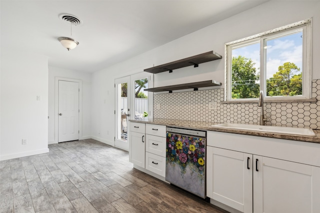 kitchen with white cabinetry, dishwasher, plenty of natural light, and sink