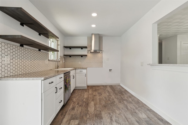 kitchen with white cabinetry, sink, wall chimney range hood, stainless steel dishwasher, and backsplash