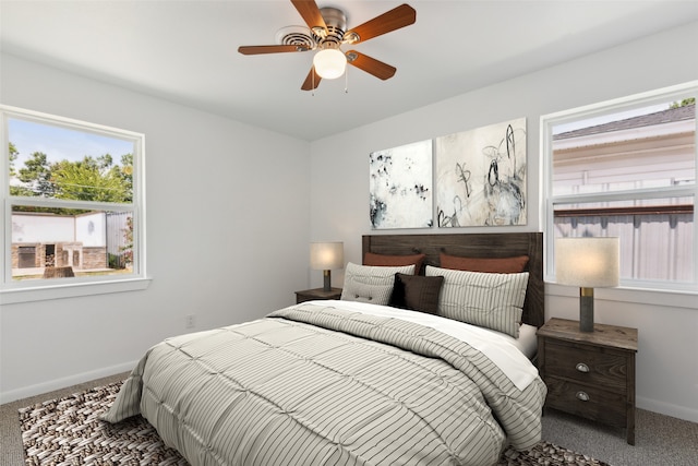 carpeted bedroom with ceiling fan and multiple windows