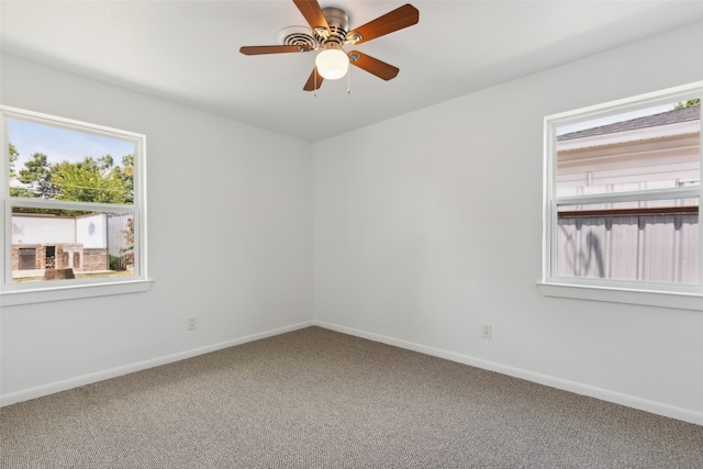 carpeted empty room featuring ceiling fan and a wealth of natural light