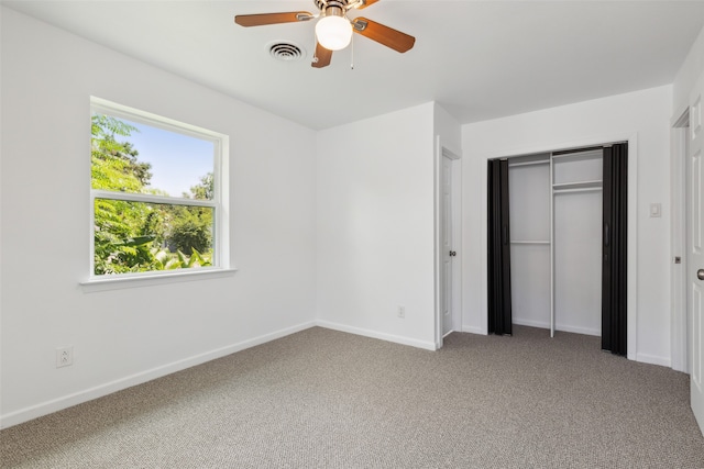 unfurnished bedroom with ceiling fan, light carpet, and a closet